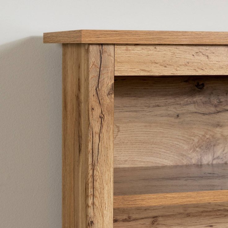 a close up of a wooden shelf against a wall