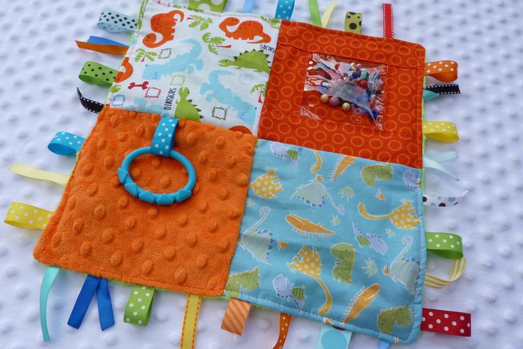 an orange and blue quilted baby bib laying on top of a table