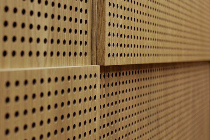 a close up view of some wood with black dots on the wall and in the background