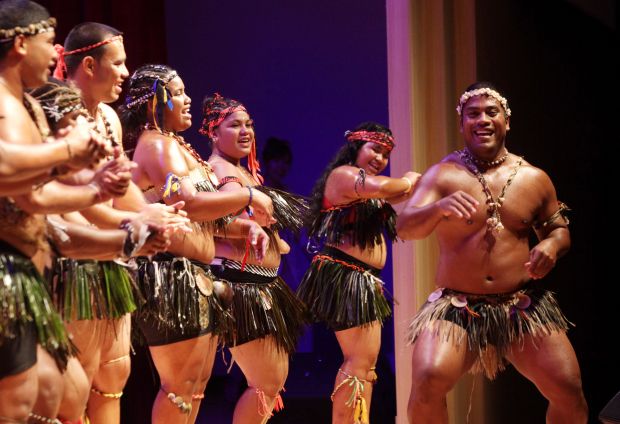 a group of men and women in costumes on stage