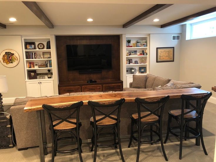 a living room filled with furniture and a flat screen tv mounted above a wooden table