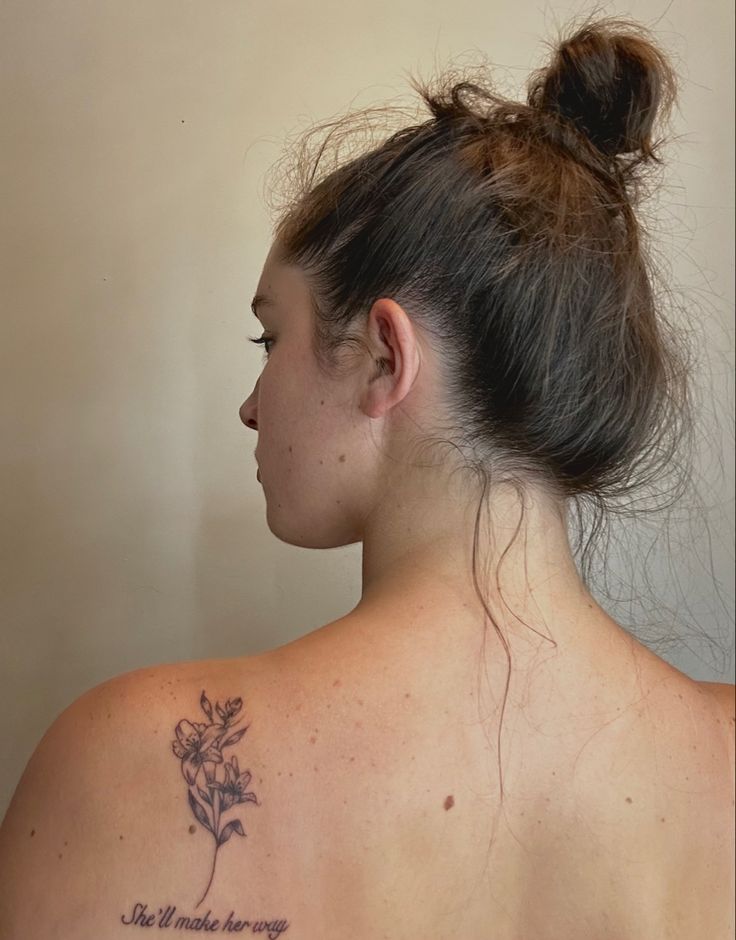 a woman with a flower tattoo on her back