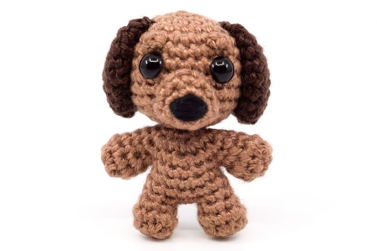 a small crocheted dog with big eyes