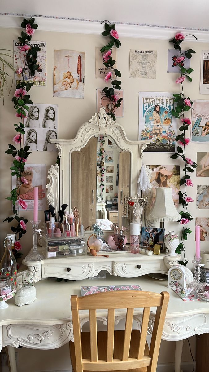 a white desk topped with a wooden chair next to a wall covered in pictures and flowers