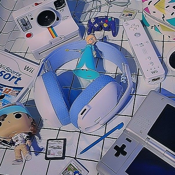 an assortment of electronic gadgets and toys on a tiled floor, including a nintendo wii game system