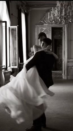 a man and woman dance in an elegant room