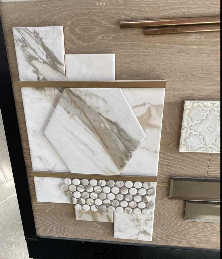 marble tiles are arranged on the wall next to a door handle and drawer knobs