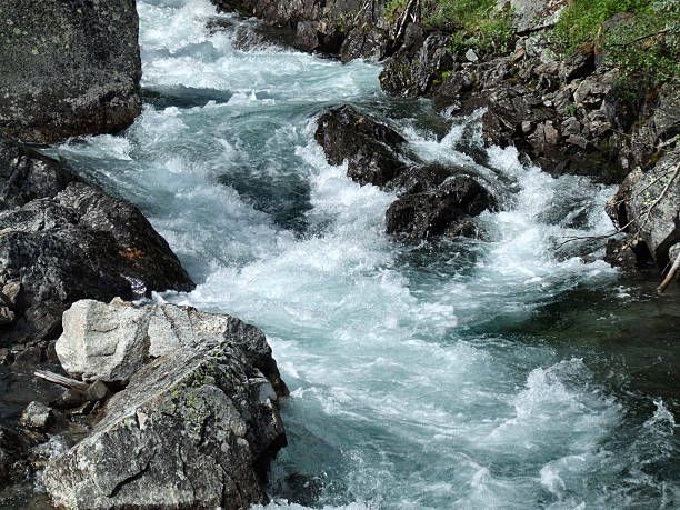 the water is rushing between some rocks