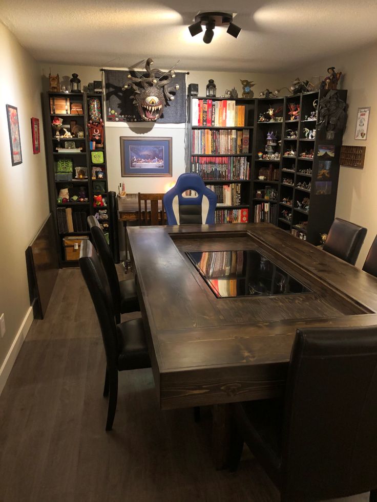 a dining room table with chairs and bookshelves in the back ground, next to a bookcase full of books