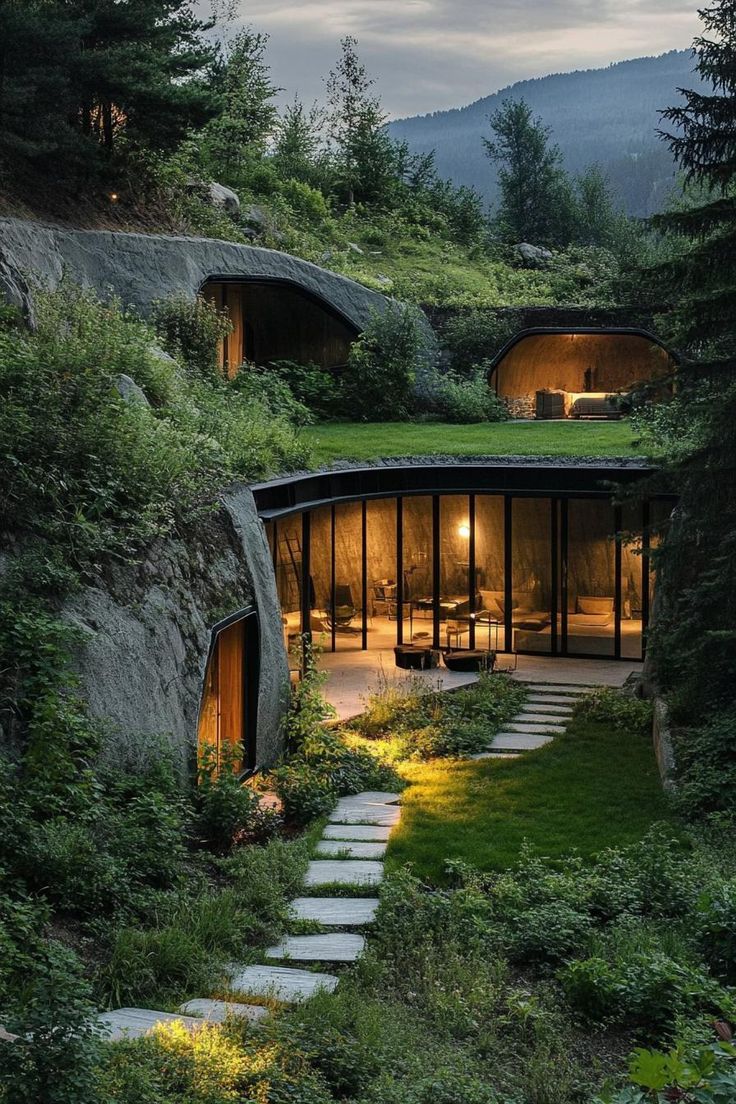 an unusual house in the woods with stairs leading up to it