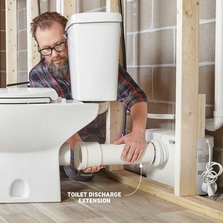 a man is fixing a toilet in the bathroom with no plumbing needed to flush it