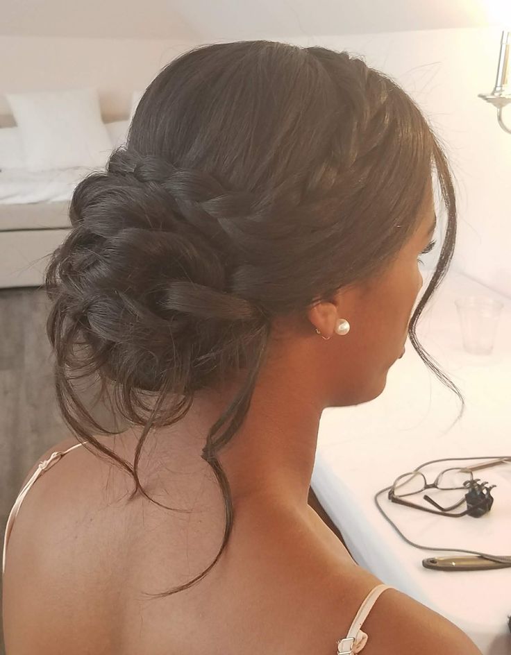 a woman sitting in front of a computer desk with her hair pulled back into a low bun