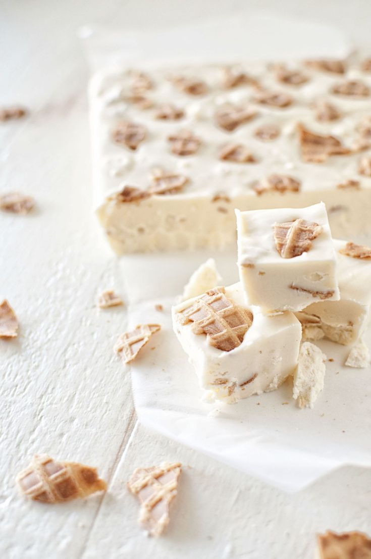 several pieces of cake sitting on top of a white tablecloth covered in chopped walnuts