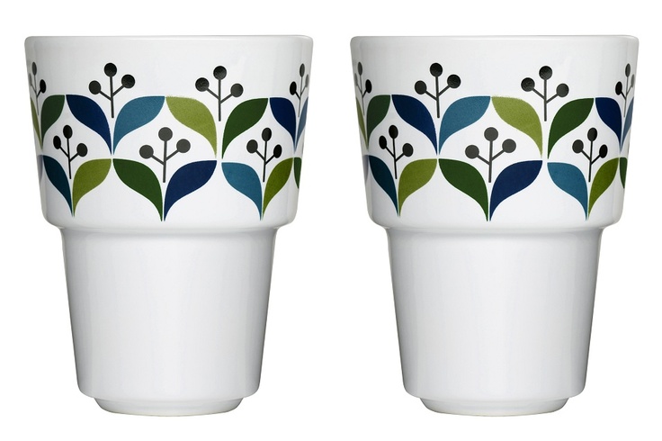 two white cups with green and blue designs on them