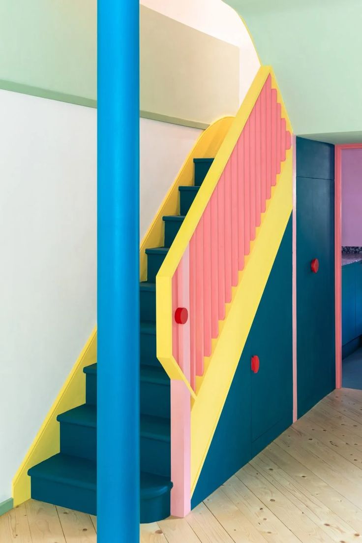 the stairs are painted bright blue, pink and yellow