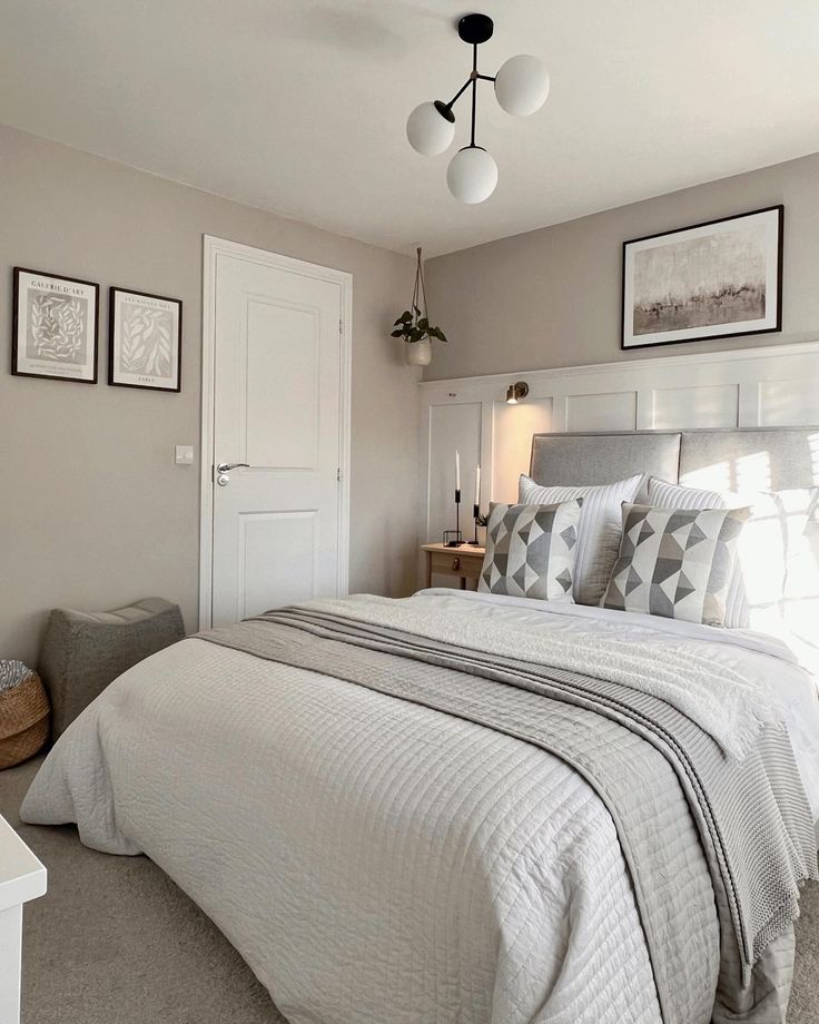 a bedroom with a large bed and pictures on the wall above it's headboard