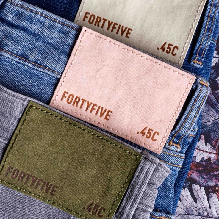 four different colored jeans with the same label on each pocket, all in different colors