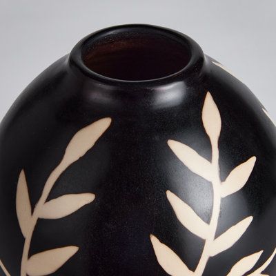 a black vase with white designs on it