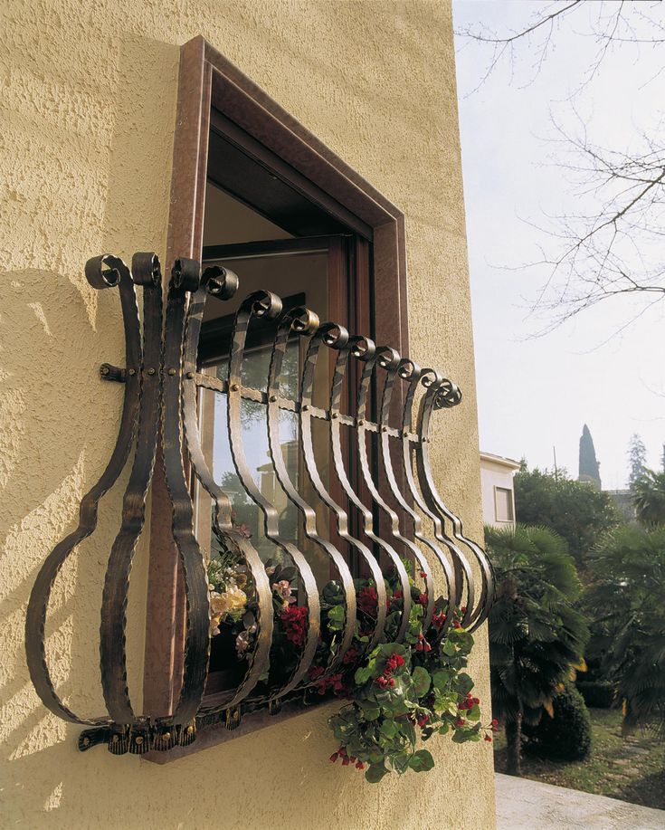 a window that is on the side of a building with flowers growing out of it