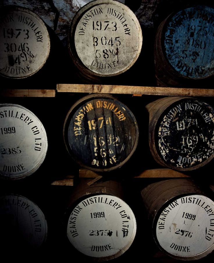 several wooden barrels stacked on top of each other in a storage area with labels and numbers