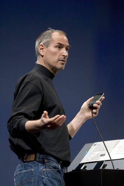 a man standing in front of a podium holding a cell phone