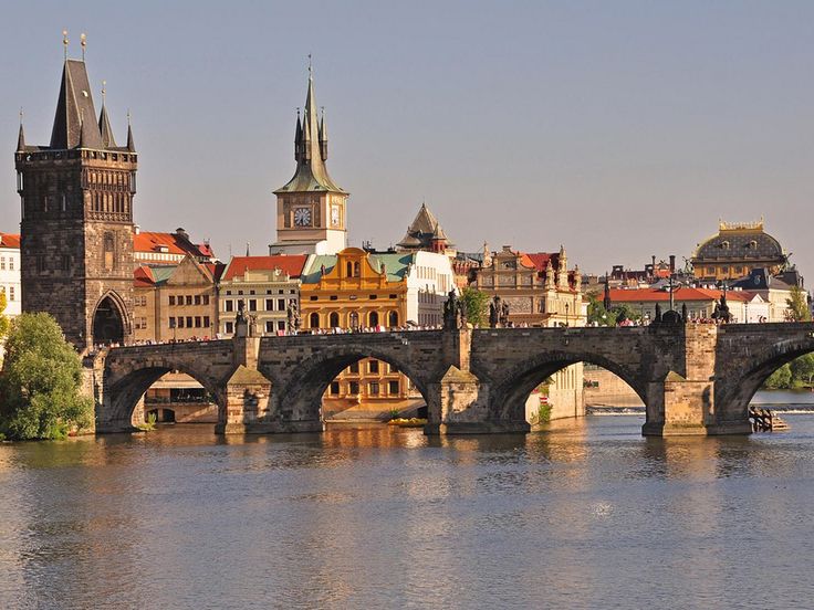 an old bridge crosses the river in prague