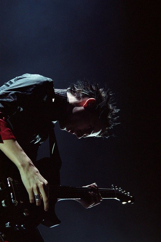 a young man playing an electric guitar on stage