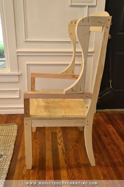 a wooden chair sitting on top of a hard wood floor next to a door and window