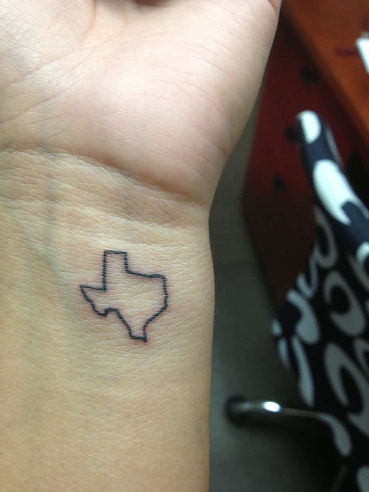 a small tattoo on the wrist of a woman's left arm, with an outline of texas