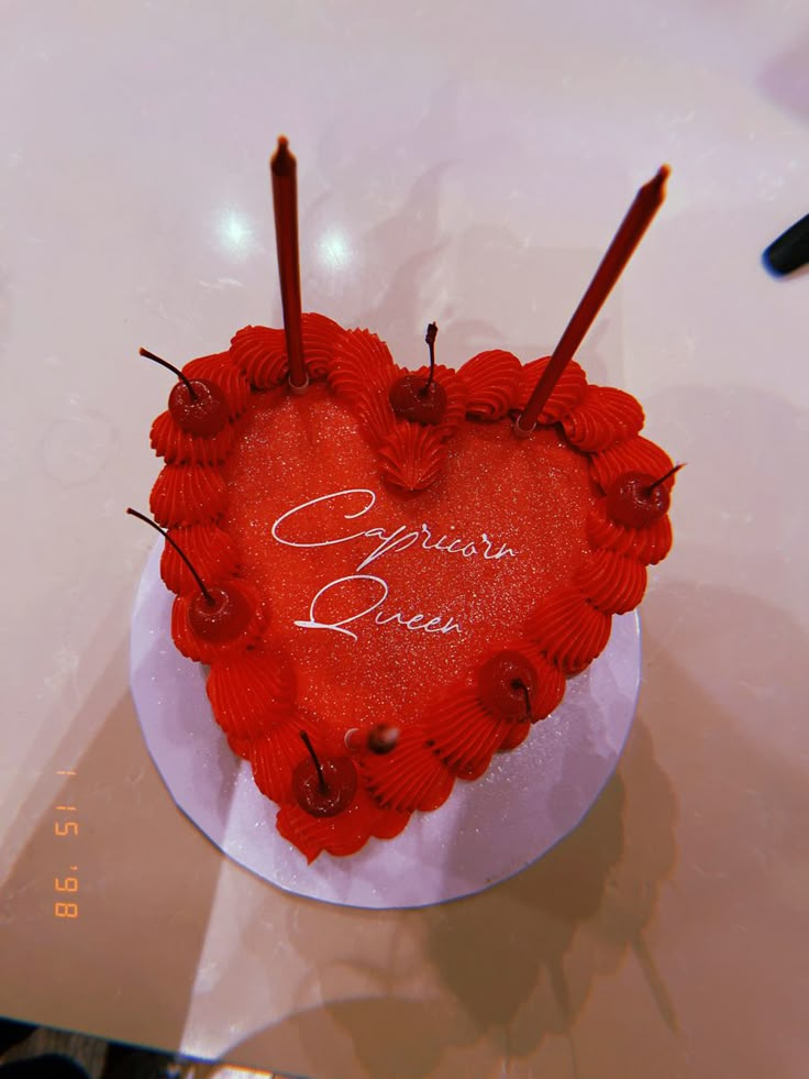 a red heart shaped cake with candles in it