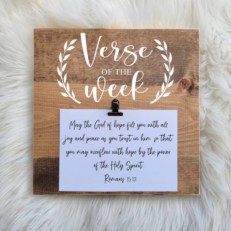 a wooden sign with the words verse of the week written in white ink on it