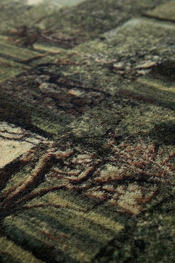 an area rug with green and brown designs on the carpet is shown in close up