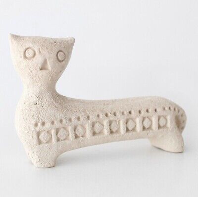 a white ceramic cat figurine sitting on top of a table