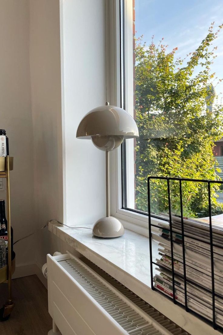 a lamp sitting on top of a windowsill next to a window sill in front of a window