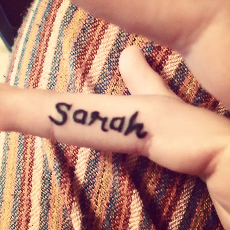 a person with a small tattoo on their left hand that says, sarh written in black ink