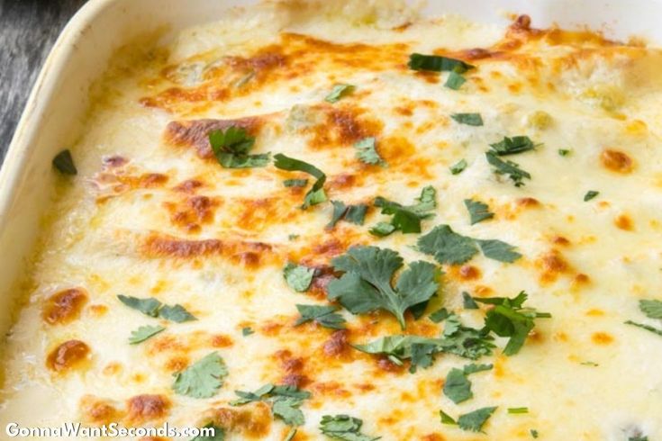 a casserole dish with cheese and parsley on top, ready to be eaten