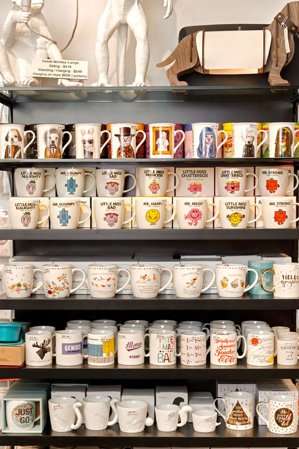 many coffee mugs are stacked on the shelves