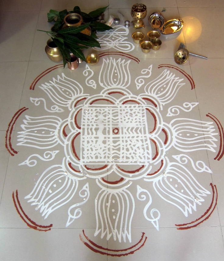 a white and red design is on the floor next to some gold bells, candles and a potted plant