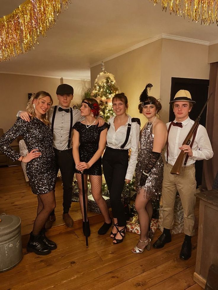 a group of people standing next to each other in front of a christmas tree