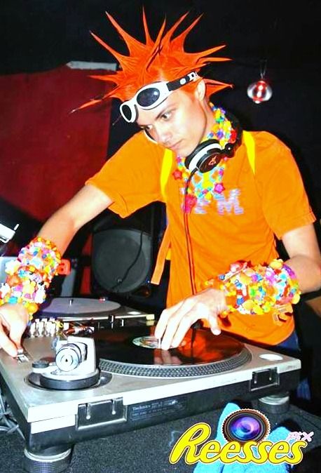 a man in an orange shirt djing at a turntable