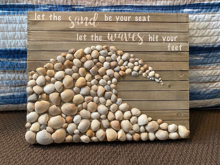 a wooden sign with shells on it that says let the sand be your seat and let the waves hit your feet