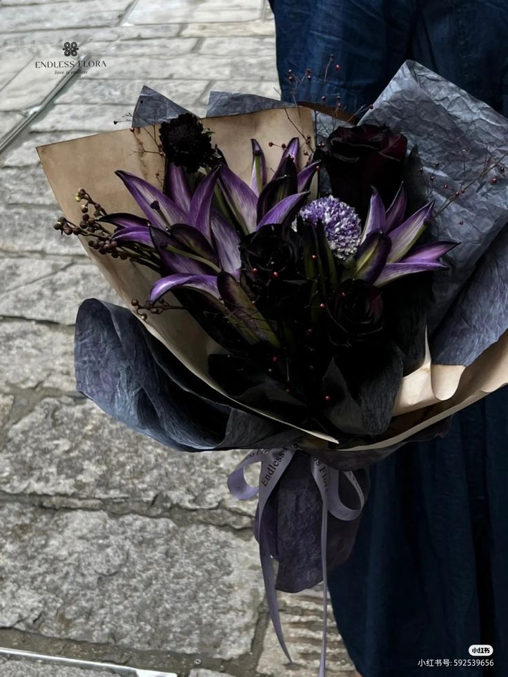 a woman holding a bouquet of purple flowers