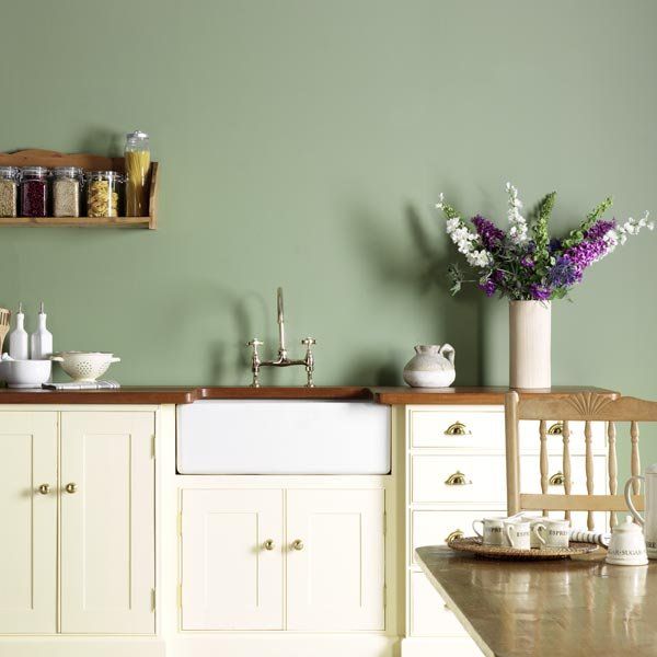 a kitchen with green walls and white cabinets