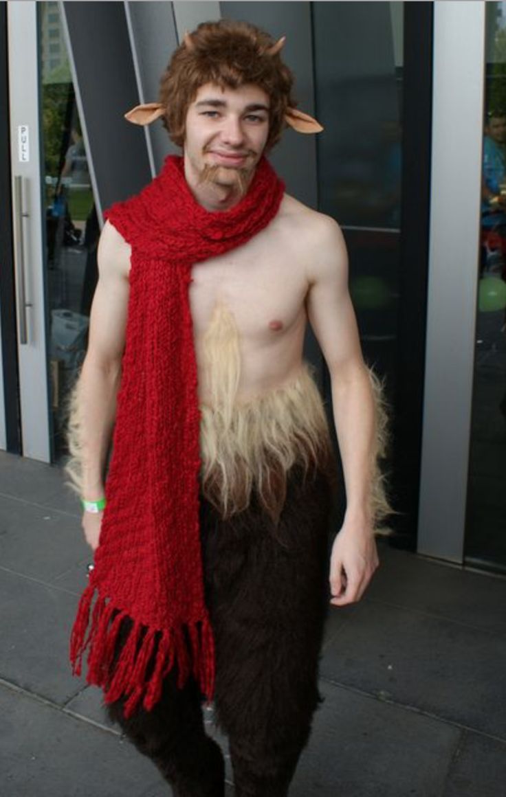 a man dressed up as a troll with long hair and horns on his head wearing a red scarf