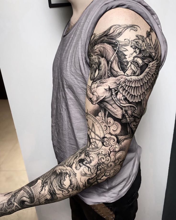 a man with a full sleeve tattoo on his arm and shoulder is standing in front of a white wall