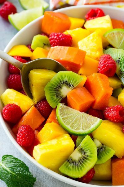 a fruit salad with kiwi, raspberries and limes