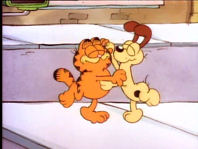 garfield the cat and his friend are playing together in cartoon form, with one holding on to the other's leg