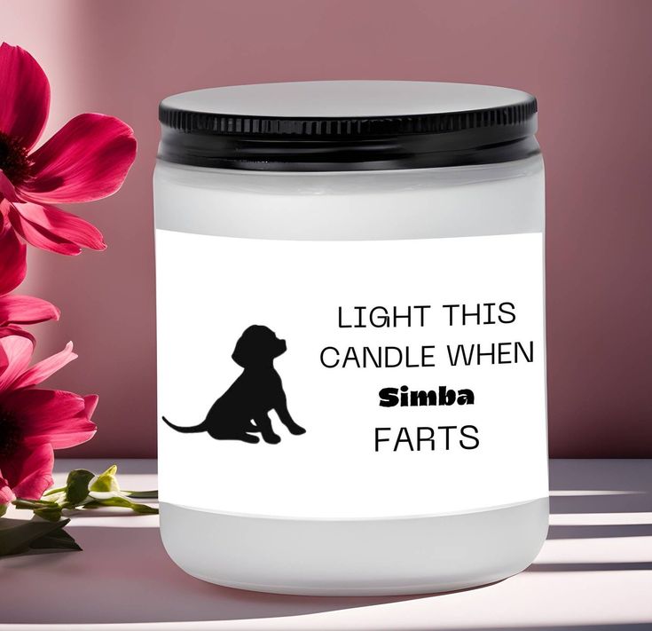 a candle that is sitting on a table with some flowers in front of it and the label says, light this candle when simba farts