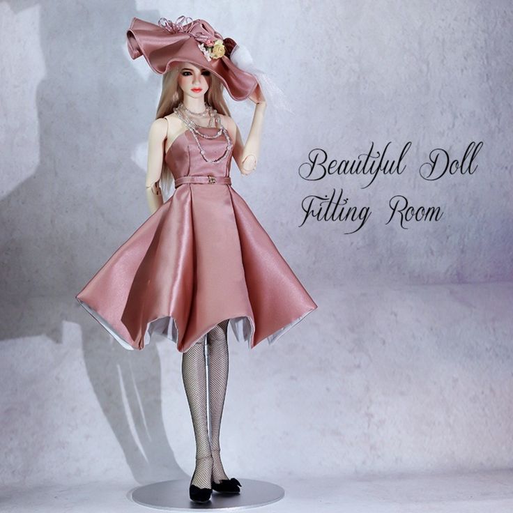 the doll is wearing a pink dress and hat