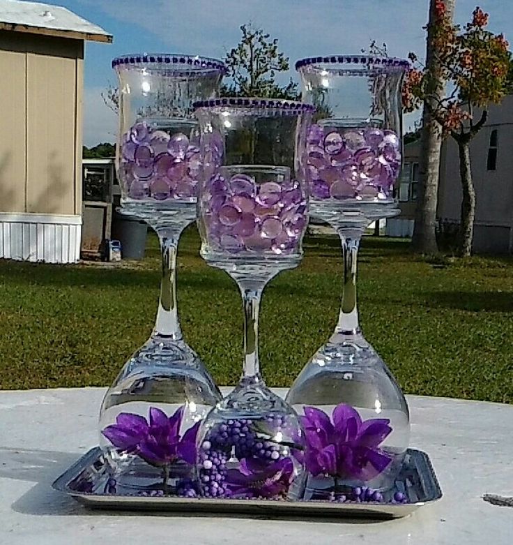 four wine glasses on a tray with purple flowers